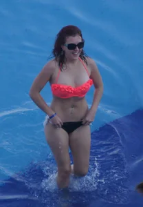 Sexy red haired girl in pink and black bikini at the pool