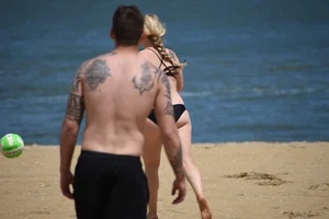 Chunky blonde in a black bikini on the beach