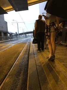 Cute Teen in Shorts on the Tram Stop