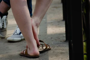 Closeups of a Candid Girl's Feet in Sandals, Red Nail Polish on Her Toenails