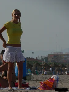 Blonde on the beach topless with big boobs and in a black thong