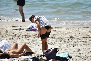 Sexy girl undressing to her bikini on the beach with an amazing body