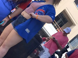 Bunch of girls in various outfits at a Cardinals baseball game
