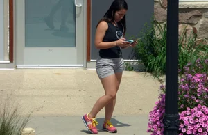 Thick brunette listening to music in shorts