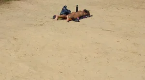 Sexy girl getting some sun laying on the beach in thong bikini