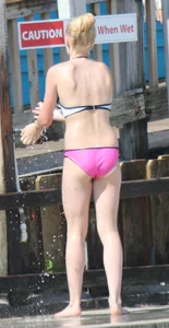Skinny blonde girl on the beach in her pink and white bikini