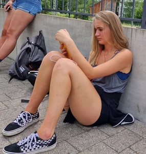 Candid Girl in Shorts Sitting on the Pavement on the Street With Her Phone, Juicy Legs Creepshots