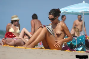 2 topless girls at the beach in thongs