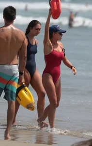 Two sexy lifeguards in red and blue swimsuits