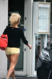 Blonde looking sexy walking in short yellow shorts