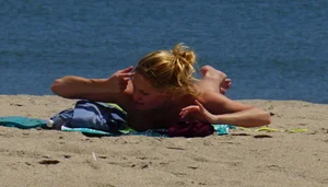 Sexy ass blonde milf on the beach in a thong with cameltoe and bending over