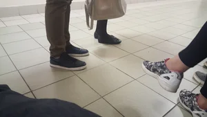 Thin Legs of a Candid Girl in a Skirt And Black Pantyhose in a College Corridor