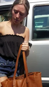Pretty babe with small boobs in black top getting out of her car