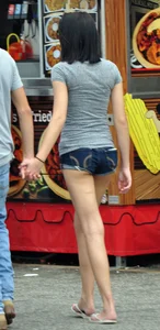Skinny brunette in tiny denim shorts showing a little cheek