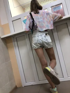 Girl in Denim Shorts With Very Skim Hot Legs And Worn Sneakers at the Reception Desk