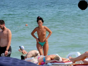 Brunette topless babe with cute tits and a nice ass in a thong bikini
