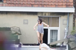 Neighbor on rooftop tanning in bikinis