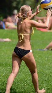 Sexy blonde girl in the park playing volleyball in her skimpy bikini