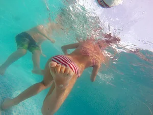 A hot teen neighbor in striped bikini underwater showing pubes