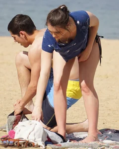 Sexy girl on the beach laying out and bending over in her bikini