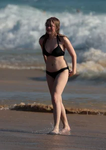 Cute bikini girl in the water in a black bikini