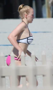 Skinny blonde girl on the beach in her pink and white bikini