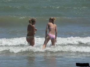 Sexy blonde on the beach in a yellow thong bikini