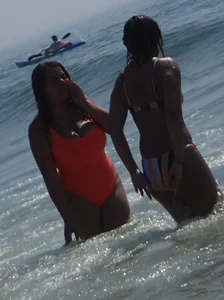 Beach girl with big boobs in an orange swimsuit