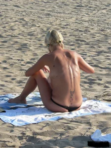 Blonde on the beach topless with big boobs and in a black thong