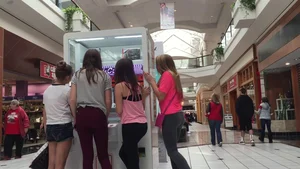 Little blonde teen in grey leggings at the mall with her friends
