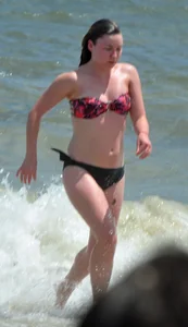 Cute beach girl in little bikini in the water