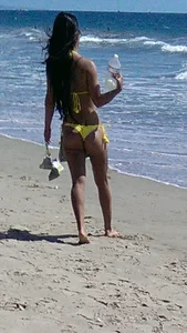 Beach babe with a nice ass and big tits in yellow thong bikini