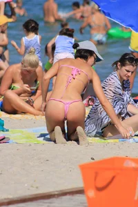 Sexy milf in pink thong bikini on the beach