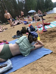 Cute Candid Girl in a Green Swimsuit With Pale Skin Lying on the Beach