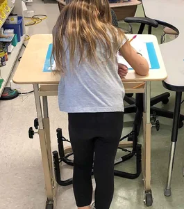 Student candid girl in leggings in class, slim legs