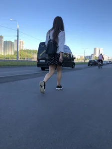 Extremely Cute Girl in a Skirt With a Backpack Passing By on the Street Gallery