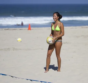 Hot girls playing beach volleyball in bikinis and shorts