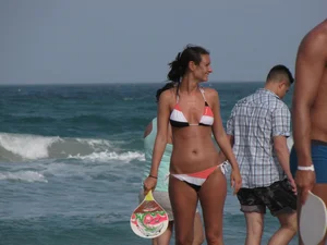 Skinny and sexy lady in a bikini playing on the beach