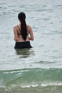 Brunette girl in black shorts and bikini top on the beach