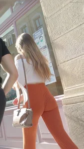 Girl with a sweet ass in tight flared orange pants and braless boobs bouncing