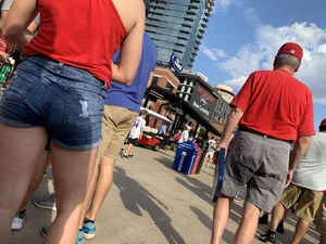 Bunch of girls in various outfits at a Cardinals baseball game