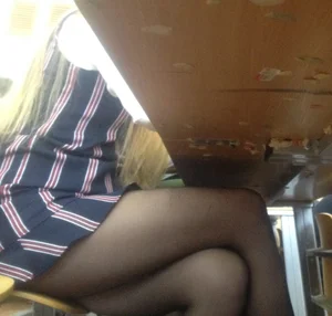 Girl in Striped Short Dress Sitting at a Dest in College Classroom in Dark Pantyhose