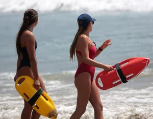 Two sexy lifeguards in red and blue swimsuits