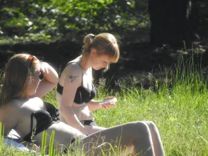 Two sexy friends in black bikinis laying out