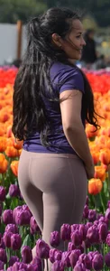 Cute babe in tight leggings taking pictures in flower fields