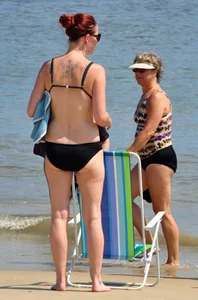 Tattooed redhead milf in a bikini at the beach