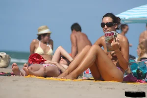 2 topless girls at the beach in thongs