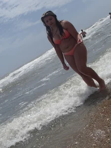 Thick beach girl with big boobs in a peach bikini