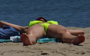 Sexy ass blonde milf on the beach in a thong with cameltoe and bending over