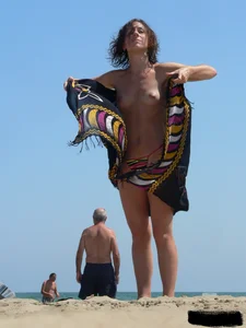 Topless beach milf looking sexy in a tiny g-string bikini